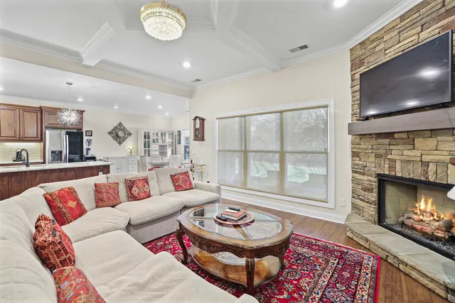 a kitchen with stainless steel appliances granite countertop a refrigerator a sink dishwasher a stove and a dining table with wooden floor