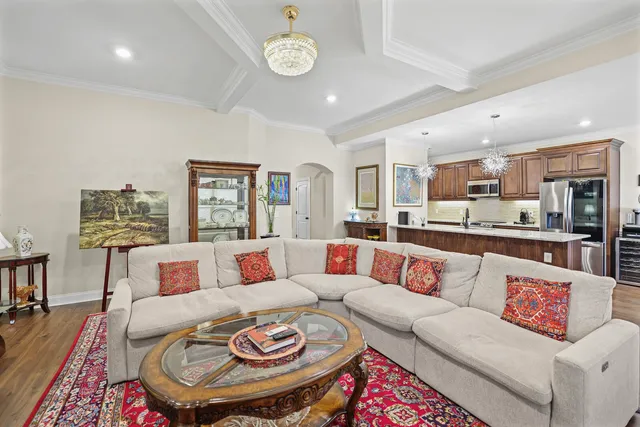 a kitchen with stainless steel appliances granite countertop a refrigerator a sink dishwasher a dining table and chairs with wooden floor