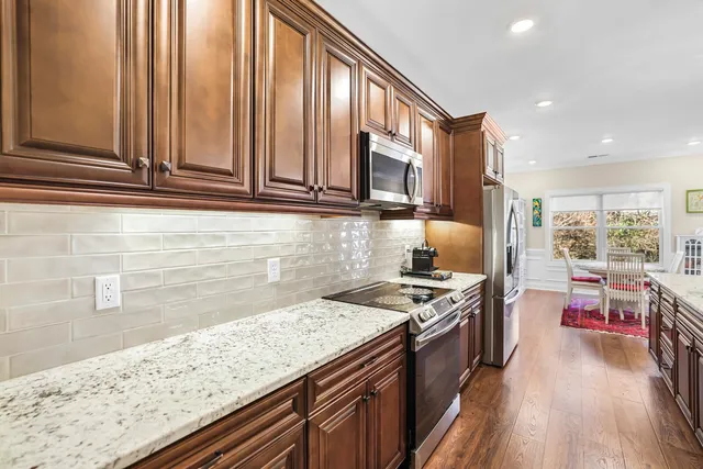 a bedroom with a bed and a dresser with wooden floor