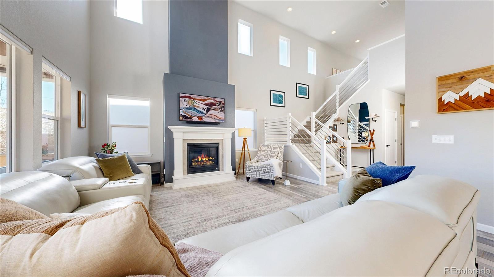 1107 Basalt Ridge Loop Castle Rock, CO 80108 - Photo 4 of 50 a living room with furniture a fireplace and a flat screen tv