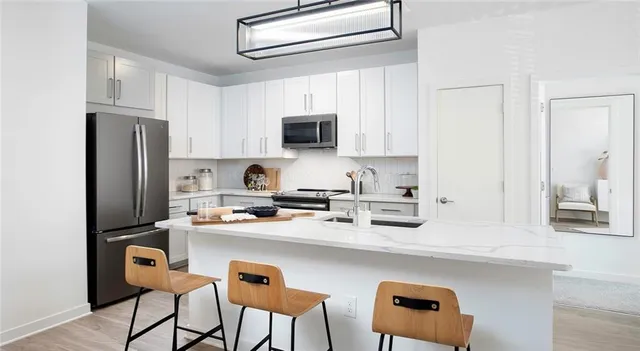 a kitchen with stainless steel appliances a stove refrigerator sink and cabinets