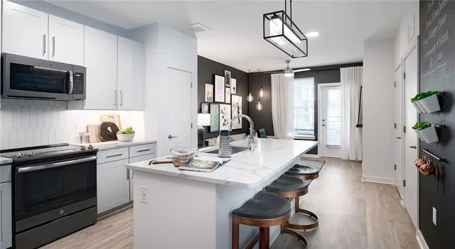 a kitchen with a table chairs stove and microwave