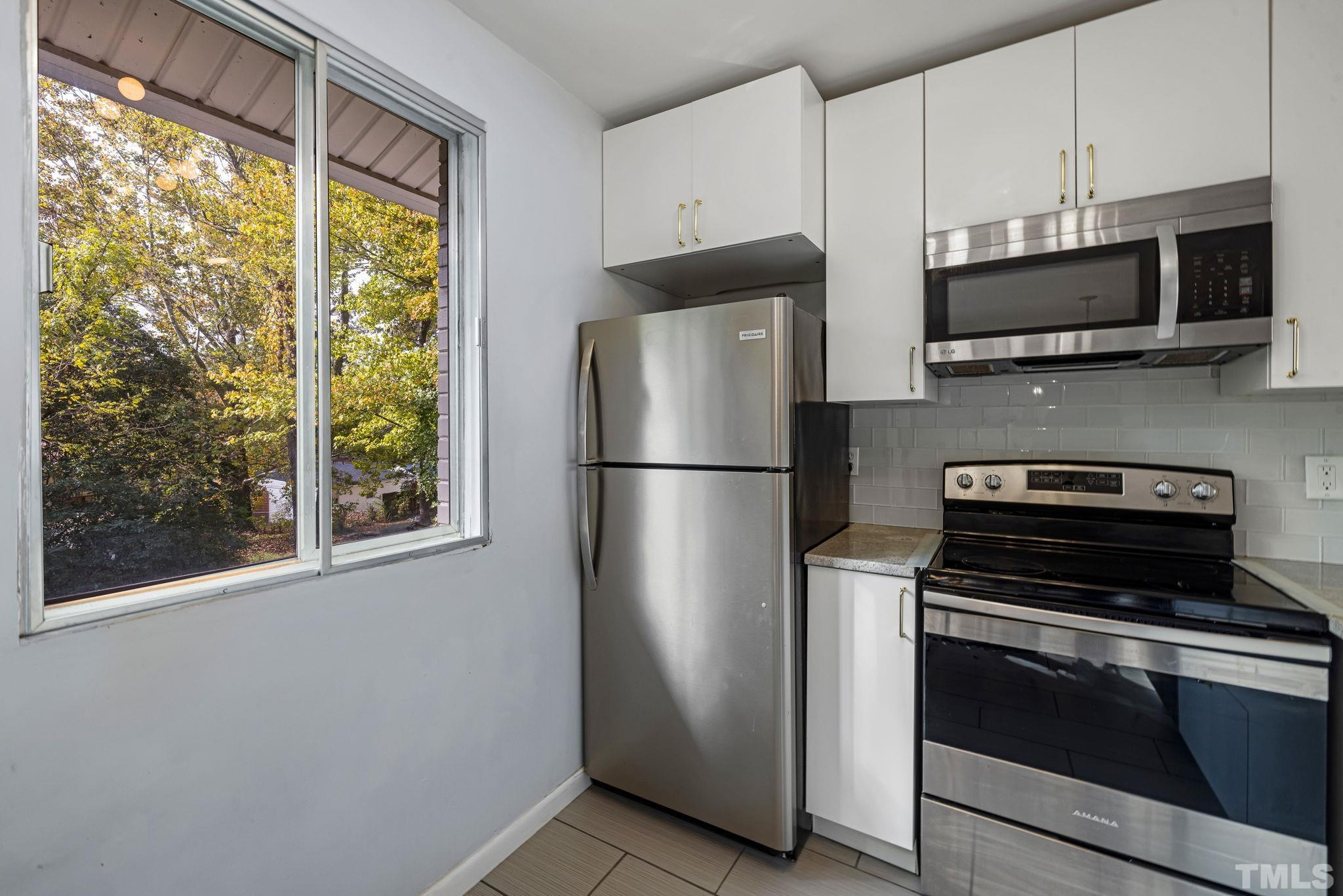 1116 Kitt Place Raleigh, NC 27610 - Photo 11 of 33 a kitchen with stainless steel appliances a refrigerator stove and microwave