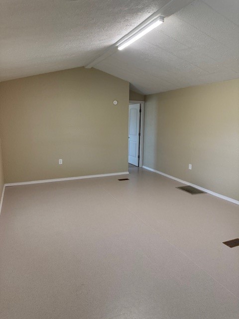22786 Cuttler Road New Caney, TX 77357 - Photo 6 of 12 This photo shows a spacious living room, with vaulted ceiling and a doorway leading to Primary bedroom.