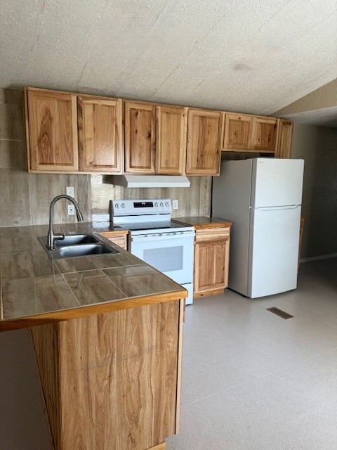 22786 Cuttler Road New Caney, TX 77357 - Photo 7 of 12 This kitchen features natural wood cabinets, a tile countertop, and essential appliances including a white stove and refrigerator. The design is simple and functional, ideal for everyday cooking needs.