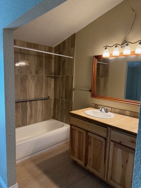 22786 Cuttler Road New Caney, TX 77357 - Photo 10 of 12 The primary bathroom features a cozy setup with a wooden vanity, a single sink, and a large mirror. The bathtub is accented by a tiled wall, and there's a modern light fixture above the mirror.
