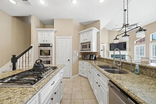a kitchen with stainless steel appliances granite countertop a sink stove and cabinets