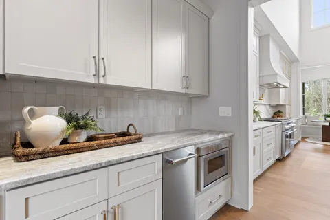 a view of a hallway with wooden floor and a livingroom with furniture