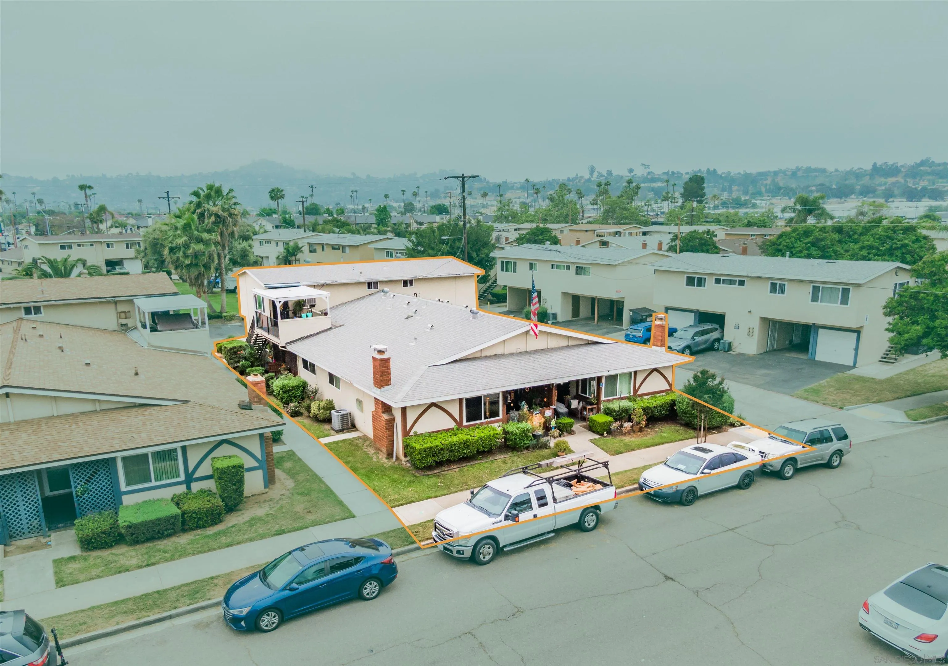 an aerial view of a tennis ground with large trees and buildings