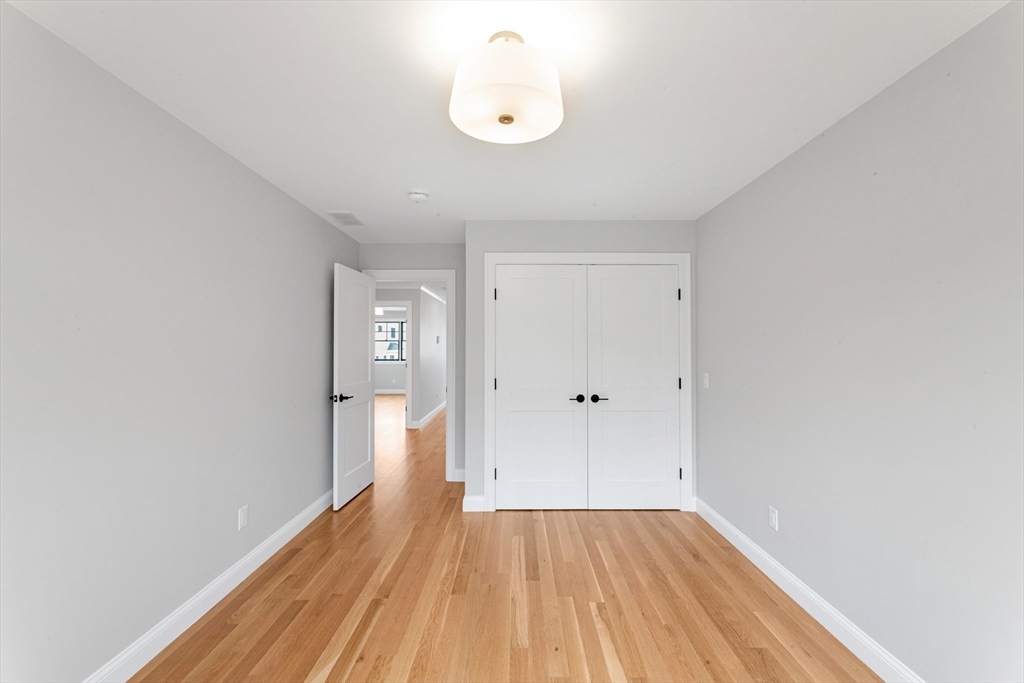 10 Starling Street Boston, MA 02132 - Photo 16 of 36 a view of an empty room with wooden floor and a window