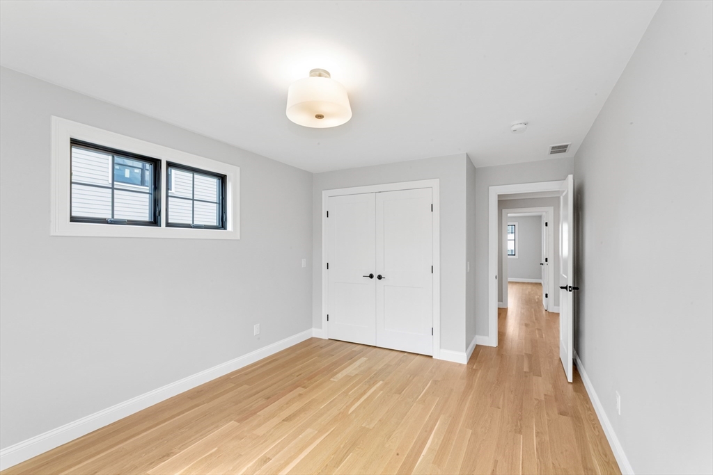 10 Starling Street Boston, MA 02132 - Photo 19 of 36 an empty room with wooden floor and windows