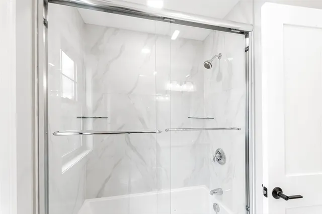 a bathroom with a shower and a bath tub