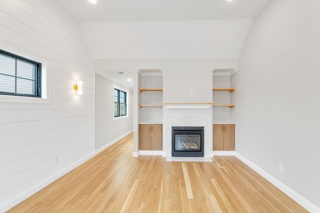 10 Starling Street Boston, MA 02132 - Photo 26 of 36 a view of empty room with wooden floor and fireplace
