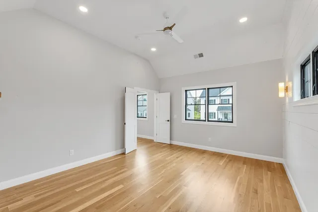 an empty room with wooden floor and windows