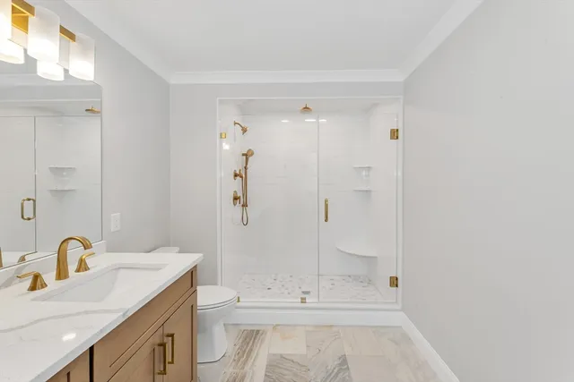 a bathroom with a sink a toilet and shower