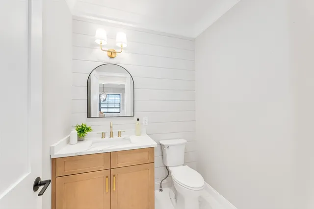 a bathroom with a sink toilet and a mirror