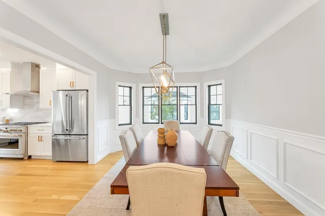 a dining room with furniture a chandelier and wooden floor