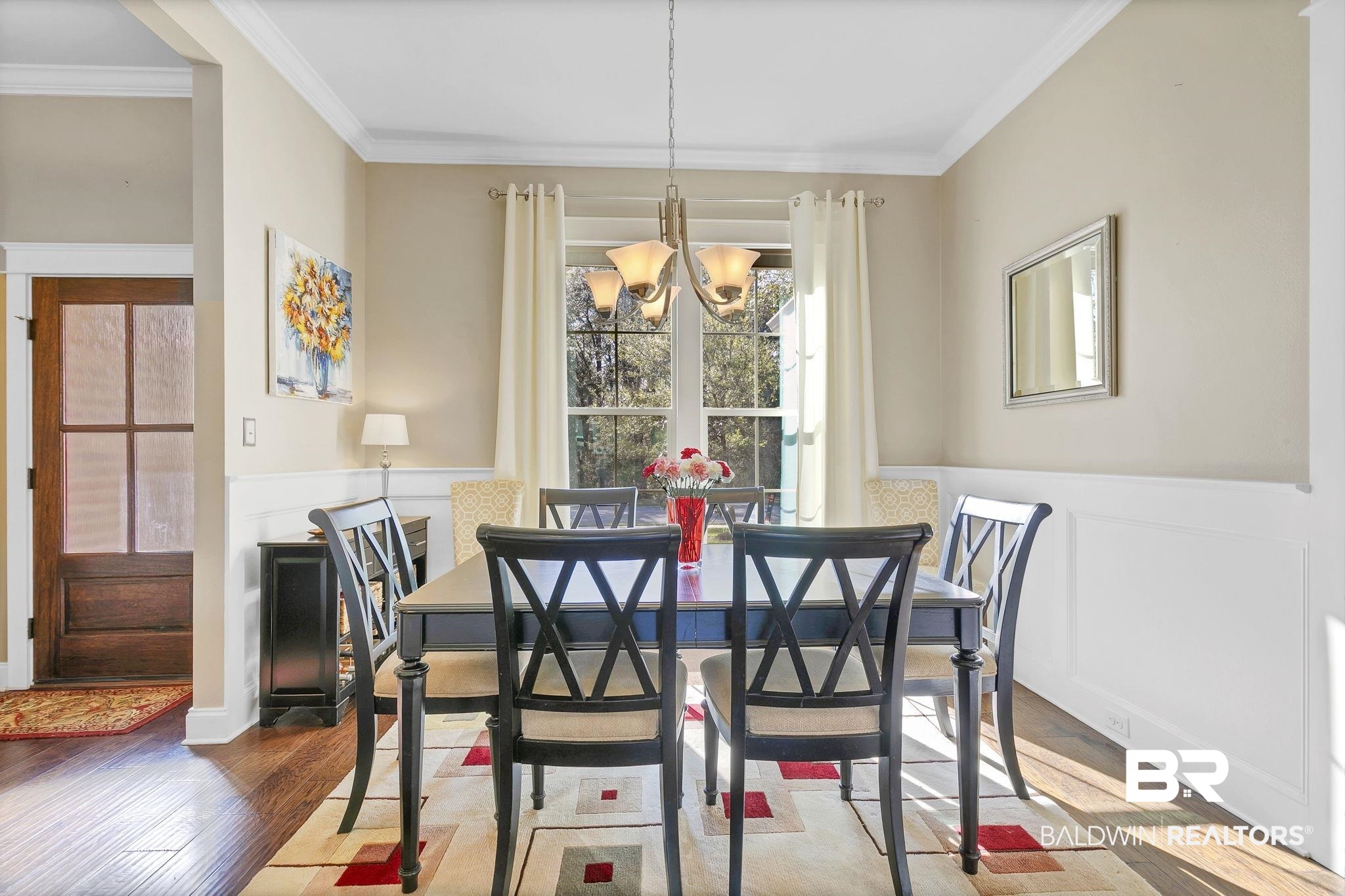 20105 Bunker Loop Fairhope, AL 36532 - Photo 4 of 65 Dining room featuring a notable chandelier, wood finished floors, wainscoting, and crown molding