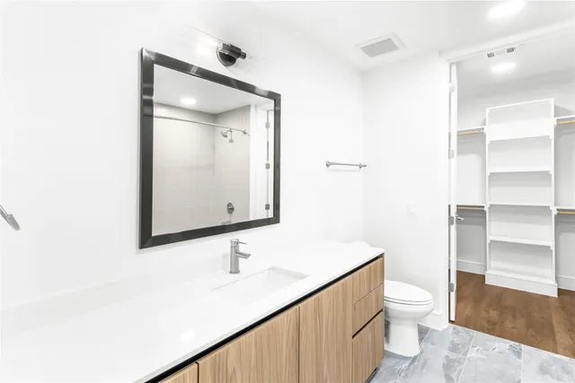 a bathroom with a sink a toilet and a mirror