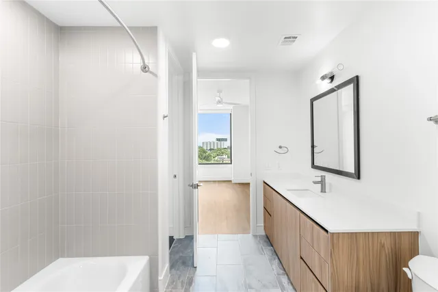 a bathroom with a tub sink and mirror