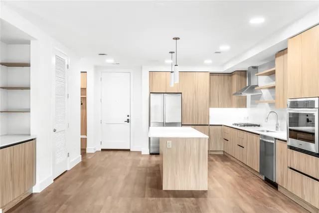 a large kitchen with a lot of counter space and wooden floor