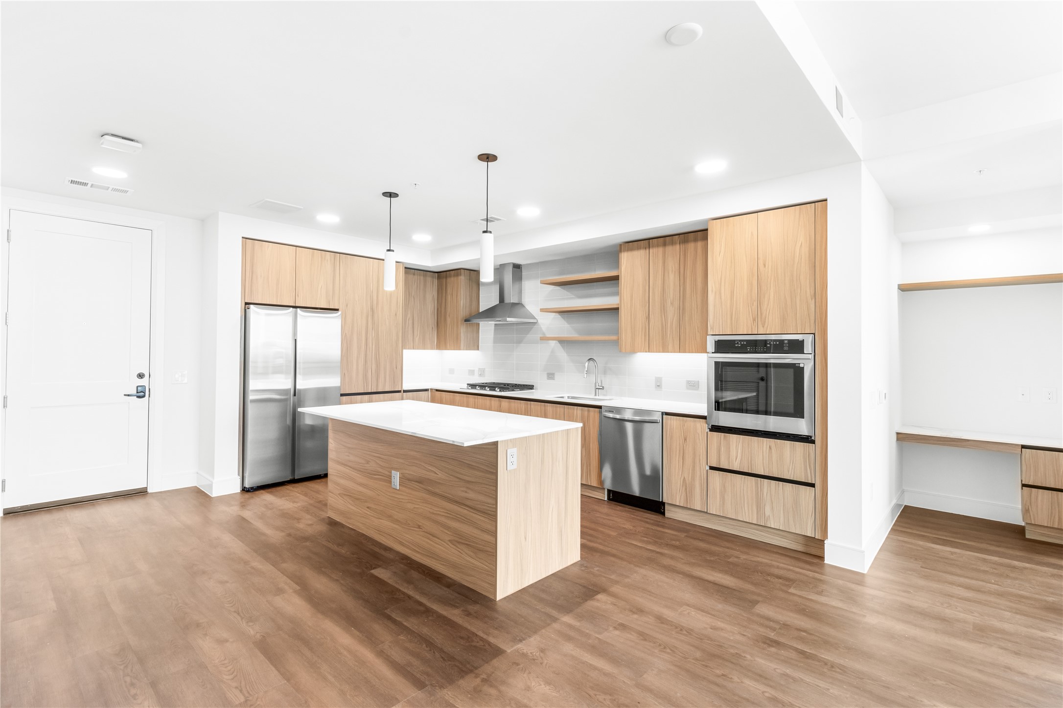 2311 Westheimer Road, Unit 714 Houston, TX 77098 - Photo 6 of 29 a large kitchen with cabinets wooden floor and stainless steel appliances
