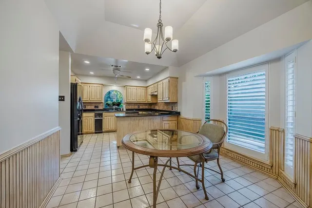 a kitchen with stainless steel appliances kitchen island granite countertop a sink a stove a dining table and chairs