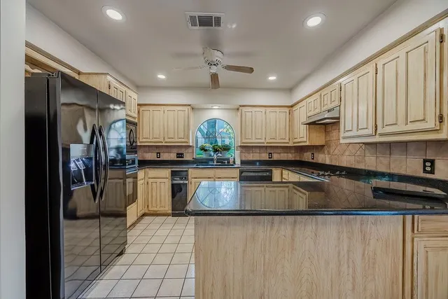a kitchen with kitchen island granite countertop a stove sink and refrigerator