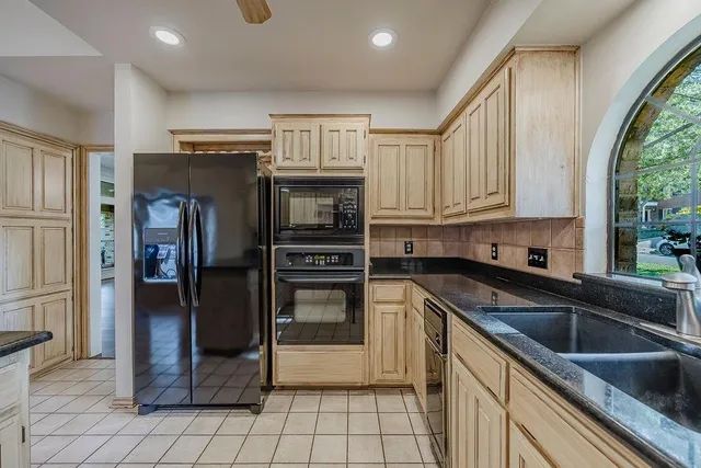 a kitchen with stainless steel appliances granite countertop a refrigerator and a sink