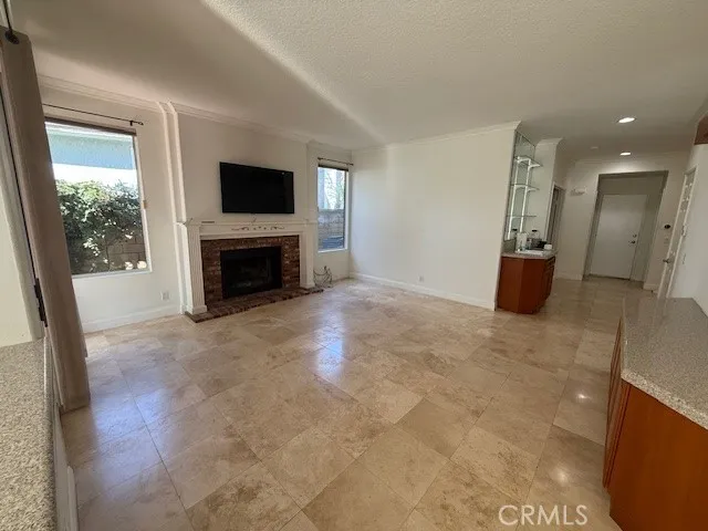 a view of a room with wooden floor fireplace and windows