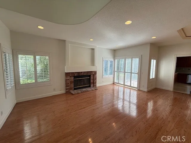 a view of empty room with window and wooden floor