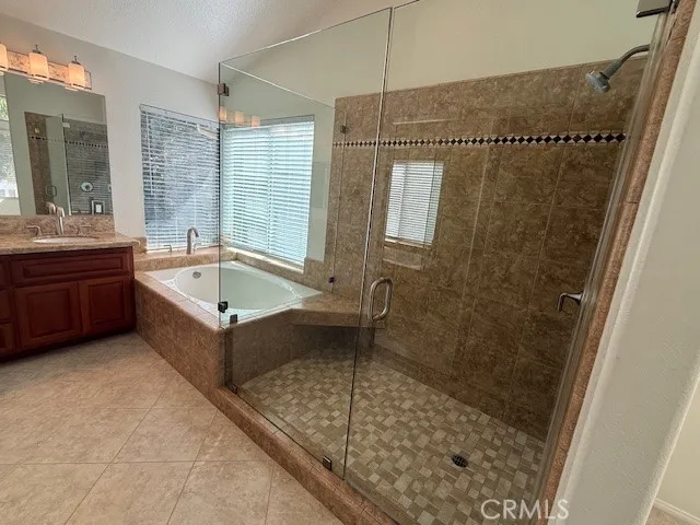 a bathroom with a granite countertop sink a large mirror and a shower