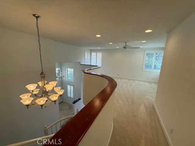 a view of a big room with wooden floor and windows