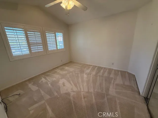 a view of an empty room with a window and chandelier