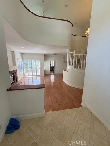 a view of a living room and chandelier fan wooden floor and kitchen view