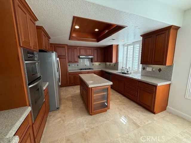 a kitchen with stainless steel appliances granite countertop a stove refrigerator and cabinets