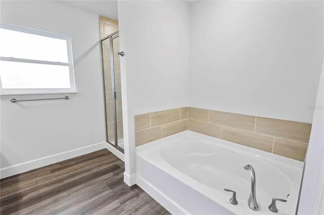 a view of a kitchen with kitchen island a sink wooden floor and a refrigerator