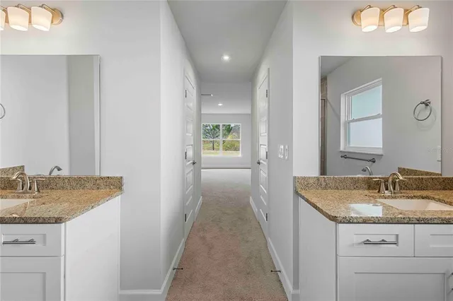 a kitchen with granite countertop white cabinets white appliances and a sink