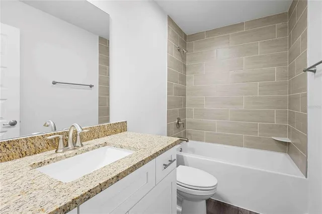 a en suite bathroom with a granite countertop sink and a mirror