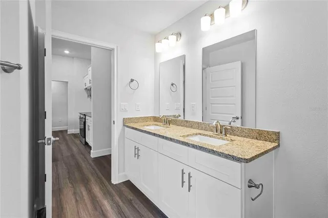 a bathroom with a granite countertop sink and tub