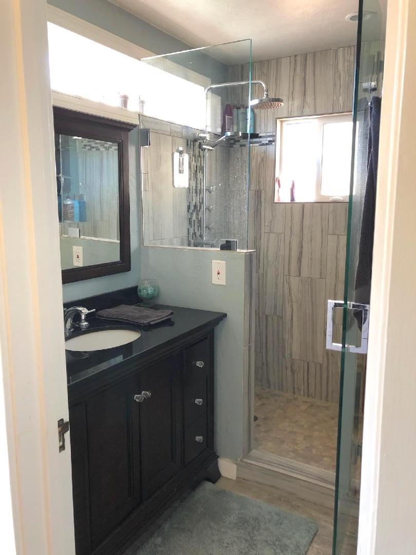 106 Maple Street Salinas, CA 93901 - Photo 11 of 22 a bathroom with a granite countertop sink a shower and a mirror