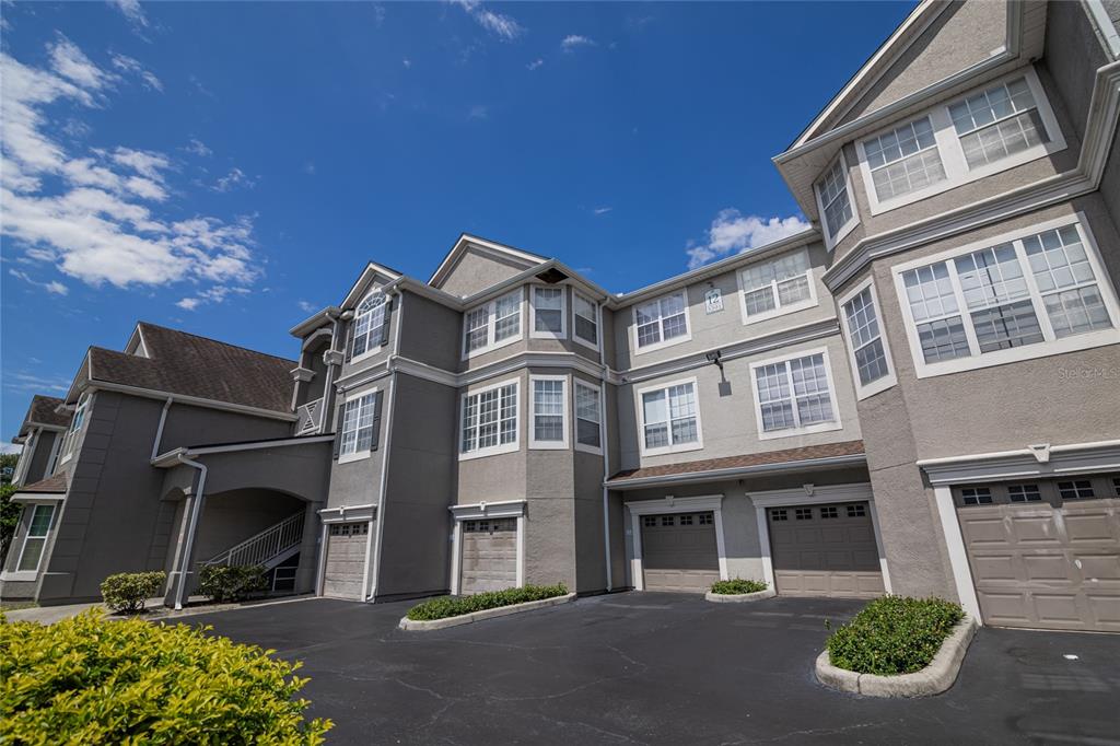 3391 South Kirkman Road, Unit 1216 Orlando, FL 32811 - Photo 2 of 33 a front view of a building with a garden