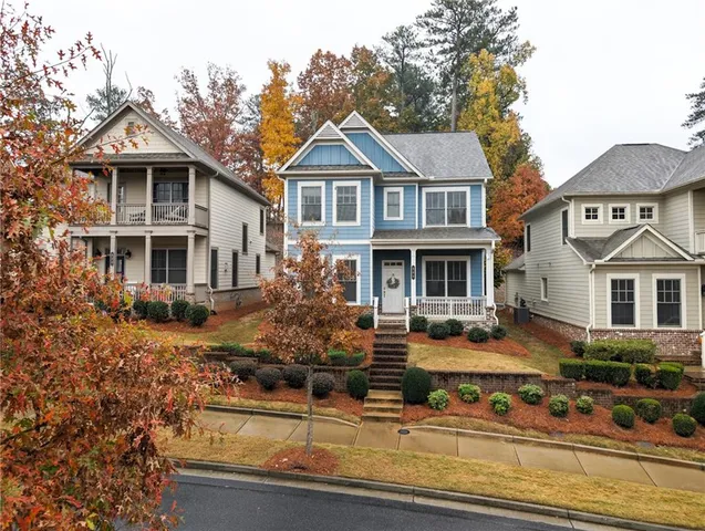 a front view of a house with porch yard and chairs