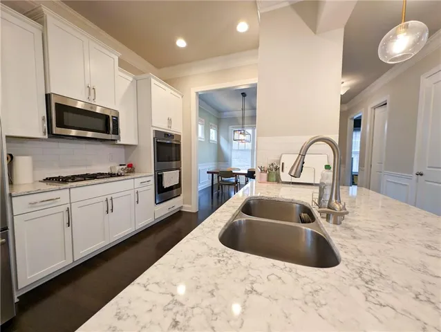 a kitchen with stainless steel appliances a sink a stove and microwave
