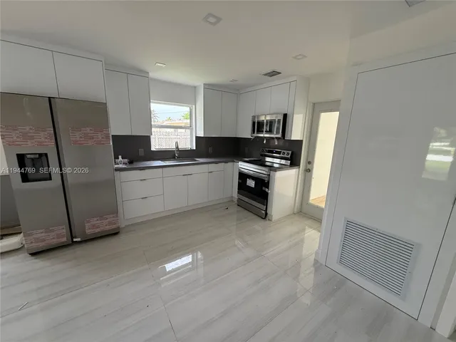 a kitchen with granite countertop stainless steel appliances and wooden cabinets