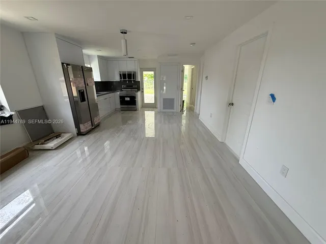 a view of a kitchen with refrigerator stove and wooden floor