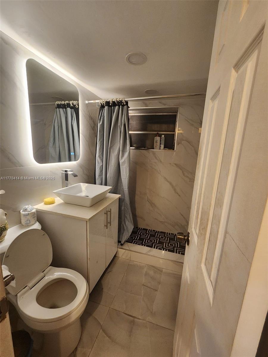 831 Northwest 140th Street Miami, FL 33168 - Photo 11 of 19 a bathroom with a toilet sink and mirror