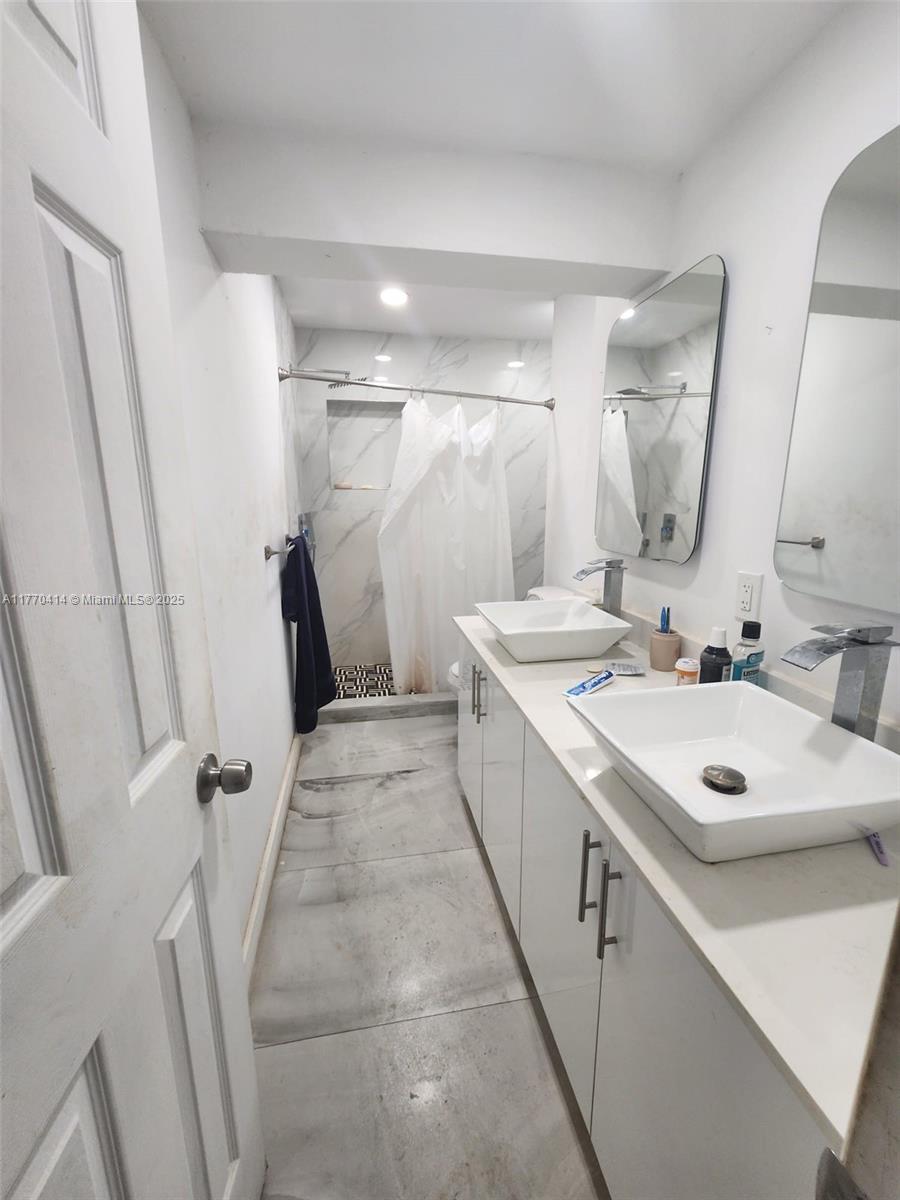 831 Northwest 140th Street Miami, FL 33168 - Photo 8 of 19 a bathroom with a sink a toilet a mirror and vanity