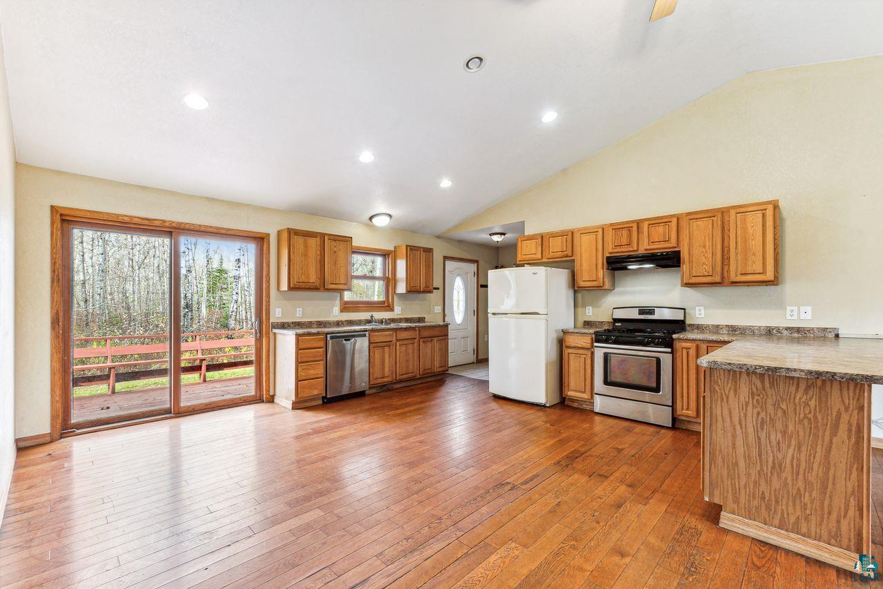 4503 Snooky Road South Range, WI 54874 - Photo 4 of 21 Kitchen with high vaulted ceiling, sink, stainless steel appliances, and wood-type flooring