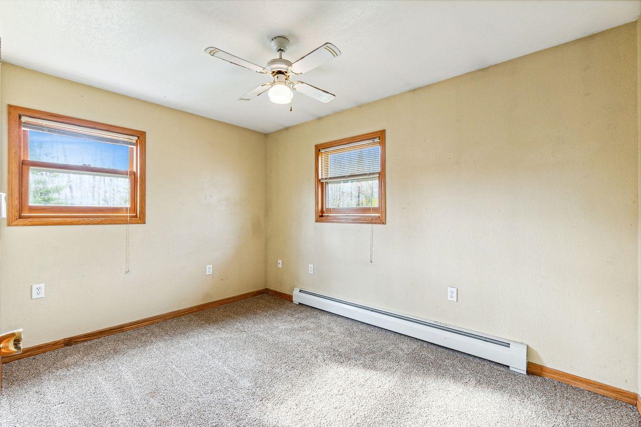 4503 Snooky Road South Range, WI 54874 - Photo 8 of 21 Carpeted empty room with baseboard heating, a wealth of natural light, and ceiling fan